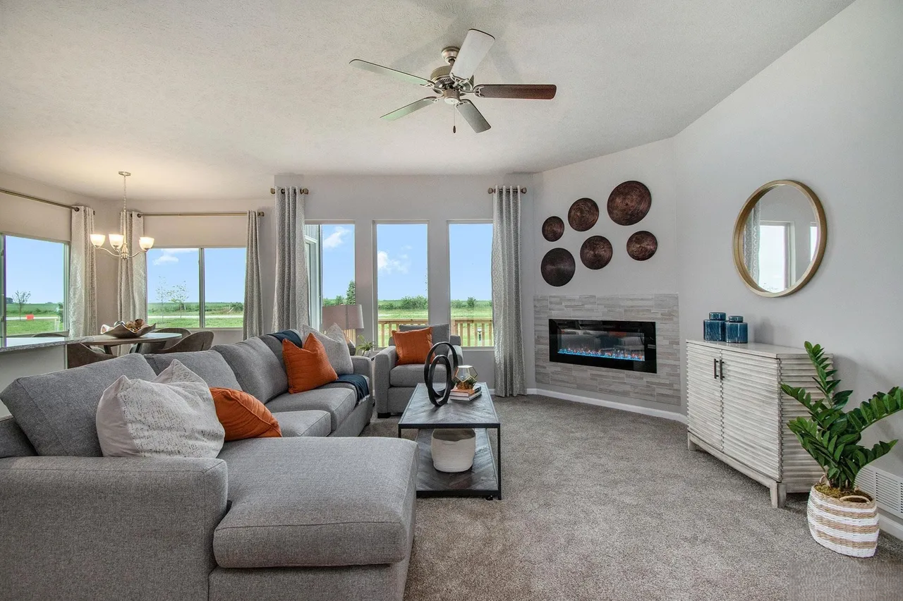 Bright, open-concept living room in a Denton, Nebraska area home with modern fireplace, large windows and neutral decor